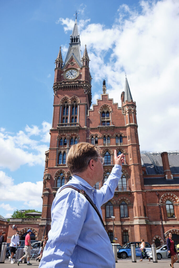 Ben points to the clock on the outside of the St. Pancras station 